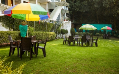 Outdoor lawn seating area with tables and colorful umbrellas at the resort